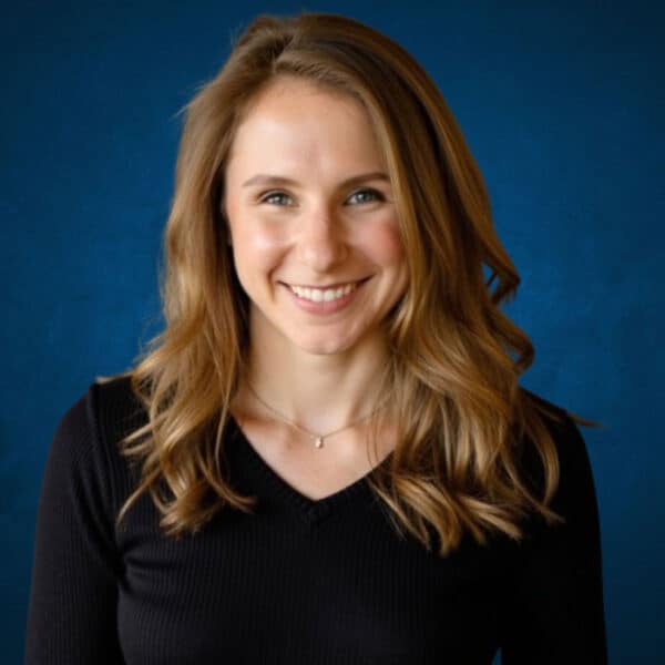 Smiling young woman with wavy hair at Alaska Hand Rehab clinic.