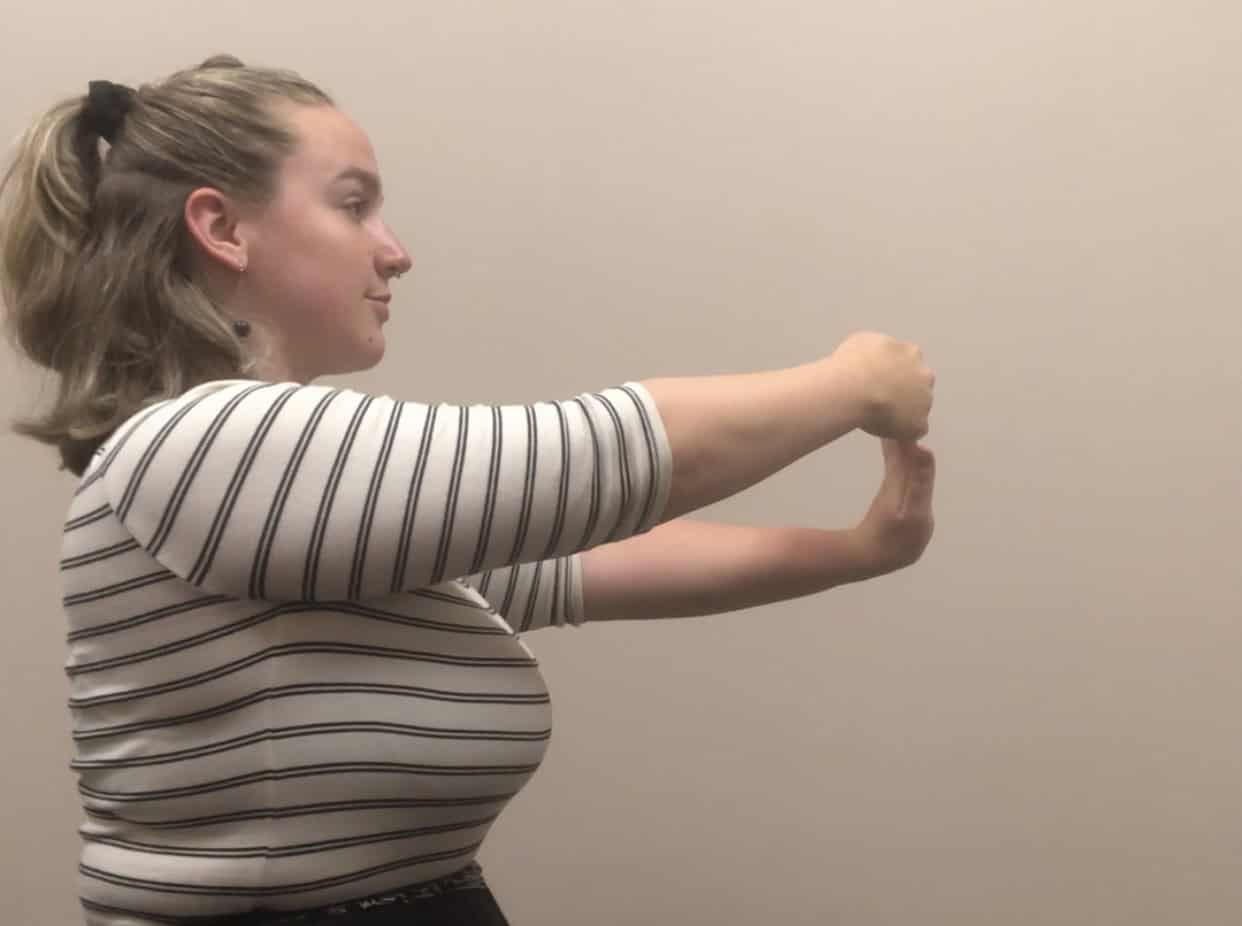 Woman performing hand stretching exercise for elbow injury rehabilitation.