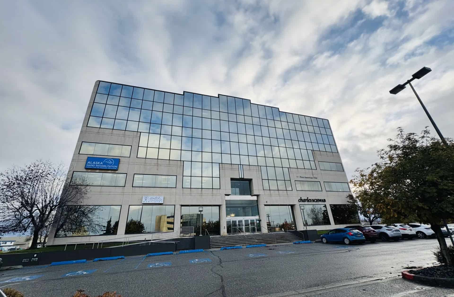 Modern office building with reflective glass facade in Alaska.